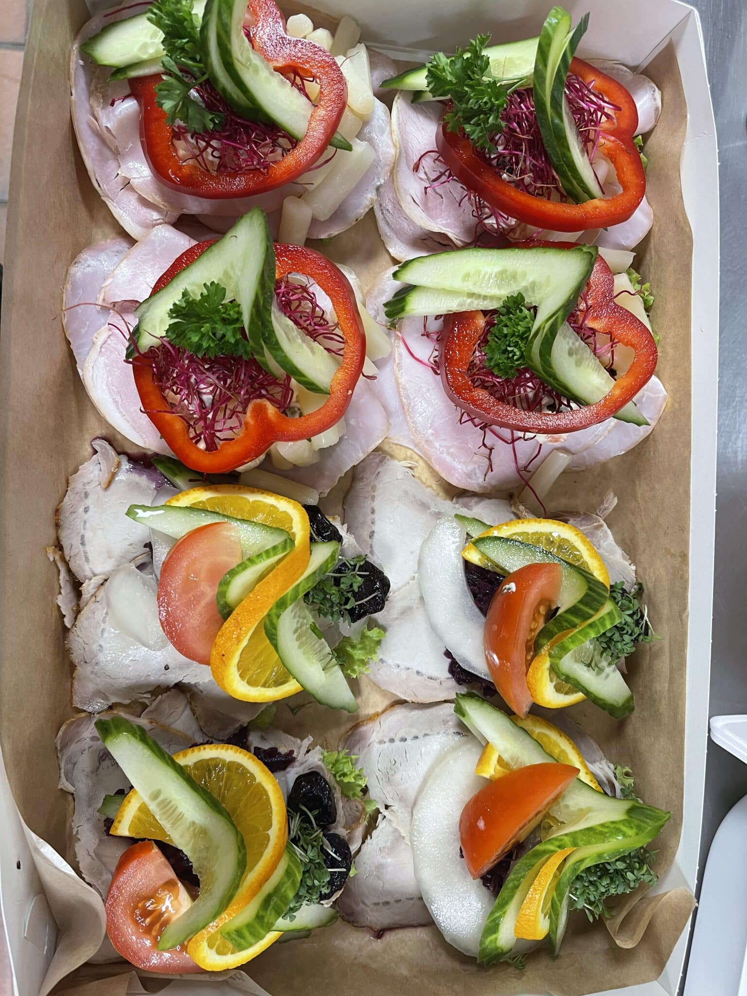 Smørrebrød med skinke, steg, grøntsager og frugtpynt